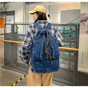 Back view of a deep blue washed canvas backpack with drawstring closure and two front pockets