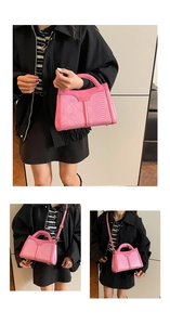 Detail of pink snake-embossed handbag with gold lettering and adjustable strap
