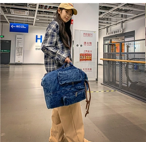 Detailed view of blue washed canvas travel bag with double front zip pockets