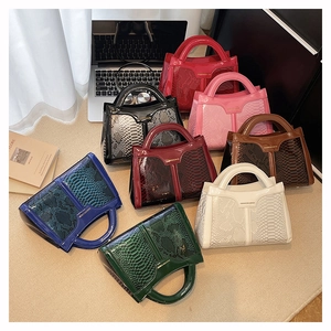 Detail shot of various snake-patterned handbags in a stylish home office setting