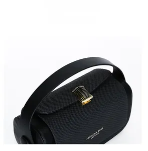 Detailed close-up of woven texture handbag with golden wave buckle and wide strap