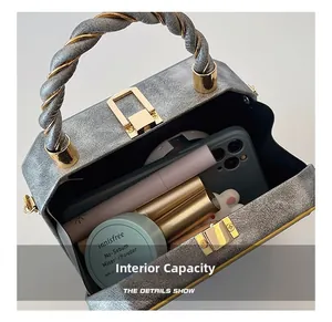 Detailed interior of grey box handbag showing space for smartphone and cosmetics