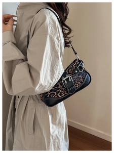 Detail view of leopard print shoulder bag with metallic buckle and black leather trim