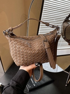 Brown woven hobo bag with adjustable strap shown in a high-quality mirror reflection