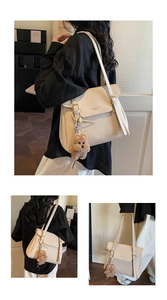 Détail du sac cabas en cuir grainé crème avec rabat et pendentif ourson décoratif