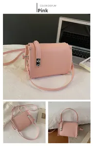 Detail of pink lychee leather baguette bag with silver metal twist lock and rivets