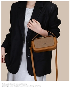 Detail of dark camel crossbody bag with woven texture flap and gold metal buckle