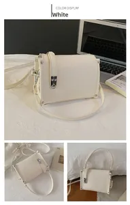 Detail view of white lychee leather handbag featuring silver rivets and metal lock closure