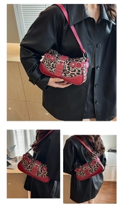 Close-up detail of leopard print faux fur bag with red leather trim and metal belt buckle