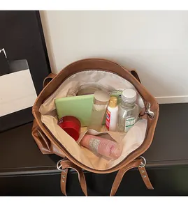 Detailansicht der geräumigen Innenfächer in der braunen Shopper-Tasche aus Kunstleder