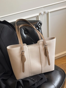 Minimalist cream white pebbled leather tote bag with adjustable brown shoulder straps