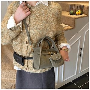Detail of olive green suede bucket bag with round coin purse charm and gold buckles