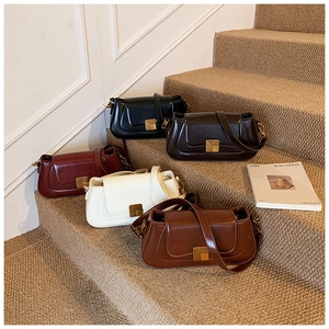 Fünf elegante rechteckige Unterarmtaschen in Schwarz, Weinrot, Beige und Braun auf Treppen