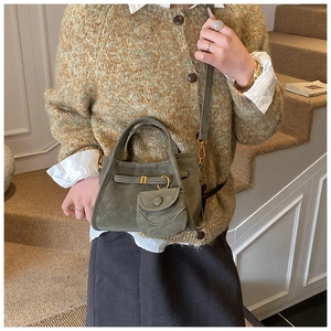 Detailed view of sage green frosted bucket bag with gold buckles and mini purse pendant