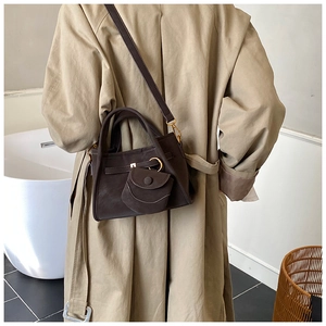 Detail of dark brown retro bucket bag with gold ring hardware and mini coin pouch