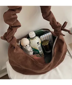 Spacious interior of brown suede tote bag holding umbrella and daily essentials