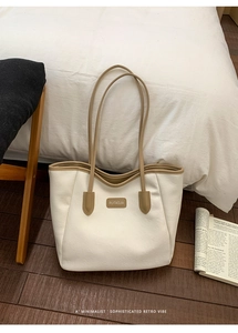 Détail du logo RUITAOJIA gaufré sur le grand sac cabas blanc avec bordure beige