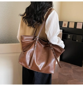 Nahaufnahme der braunen Ledertasche mit Metallösen und glatter Oberflächenstruktur