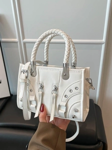 White minimalist underarm bag with vintage rivets and woven handles shown by hand