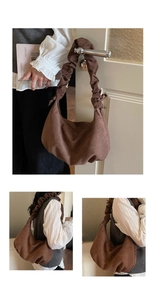 Detail of dark brown suede shoulder bag with artistic ruched strap and matte texture