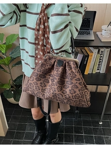 Detail of vintage leopard print tote bag with metal clasp and black handle in office setting