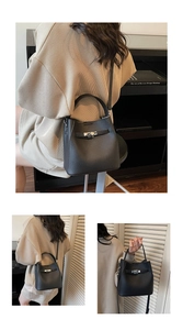 Detail of black lychee grain leather bucket bag with silver metal twist lock closure