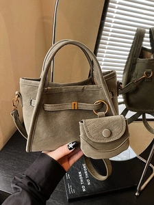 Olive green matte bucket bag with mini purse and adjustable strap in soft sunlight