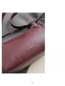 Dettaglio della borsa baguette vintage bordeaux con trama in pelle martellata e oro