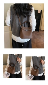 Detail of caramel brown litchi grain leather bucket bag with metallic twist lock closure