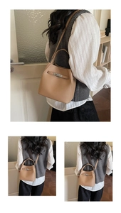 Detailed view of the khaki bucket bag showing the metal lock and textured leather finish