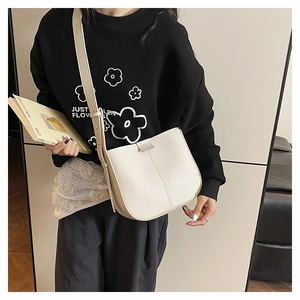 Side view of beige lychee texture leather crossbody bag showing adjustable strap and U-shape