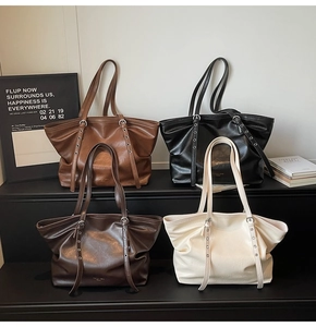 Detailansicht der strukturierten Kunstledertasche mit Metallnieten und Trageriemen