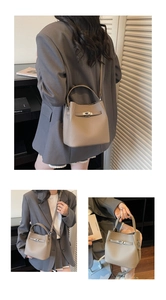 Detail of leather bucket bag showing metal twist lock and pebble grain texture