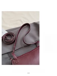 Dettaglio della borsa a cuscino bordeaux con trama in pelle e tracolla flessibile
