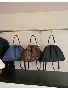 Three vintage kiss-lock bags in denim blue, leopard print and black with metal handles