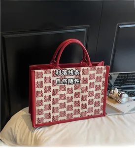 Détail du sac cabas de mariage rouge avec motif traditionnel et garniture en cuir