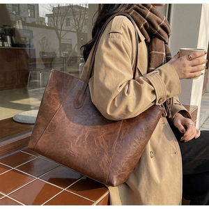 Close-up of vintage brown leather tote bag featuring embossed Street Mode Paris logo