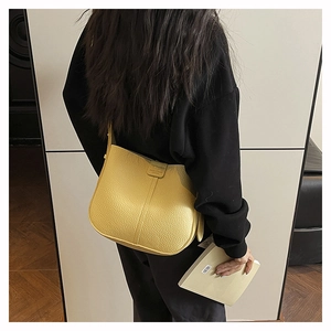Detail of yellow lychee grain leather crossbody bag with stitching and shoulder strap
