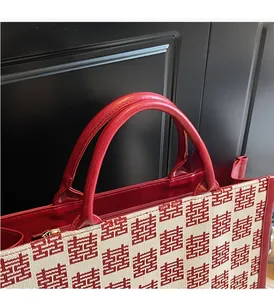 Détail du sac de mariage rouge avec motif festif de double bonheur et poignées en cuir