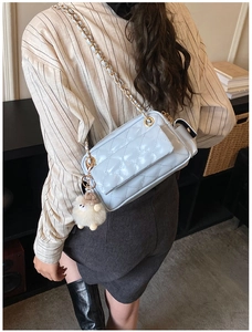 Détail du sac matelassé bleu clair avec un charmant pendentif mouton en peluche blanc