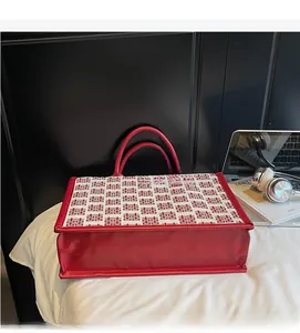 Détail du sac de mariage rouge avec doubles poignées et motif traditionnel de jacquard Xi