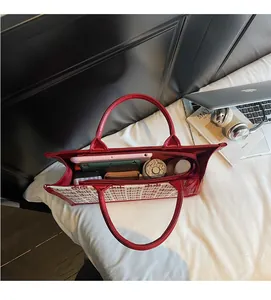 Vue de dessus d'un cabas tissé rouge et blanc montrant l'intérieur spacieux et des objets