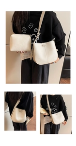Detail of creamy white litchi pattern leather handbag set with gold-tone hardware