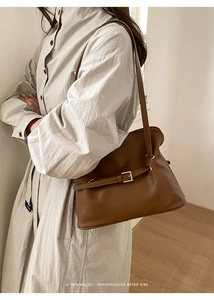 Détail d'un sac à épaule en cuir marron avec fine ceinture décorative et boucle métal