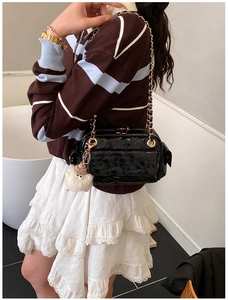 Détail du sac matelassé noir avec pendentif mouton mignon et bandoulière dorée