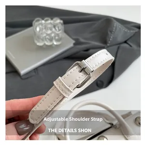 Détail d'un sac à main blanc en cuir avec bandoulière réglable et boucle en métal argenté