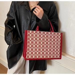 Detail of red bridal tote bag with traditional Xi character pattern and leather trim