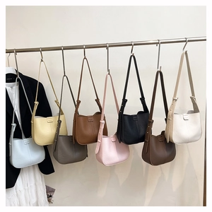 Litchi texture leather shoulder bag shown in eight versatile colors on a display rack