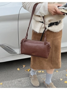 Dettaglio borsa a cilindro vintage in pelle marrone scuro con logo LIUU dorato