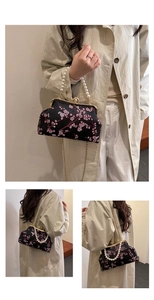 Close-up of vintage floral embroidery, pearl handle and gold frame on new Chinese style bag